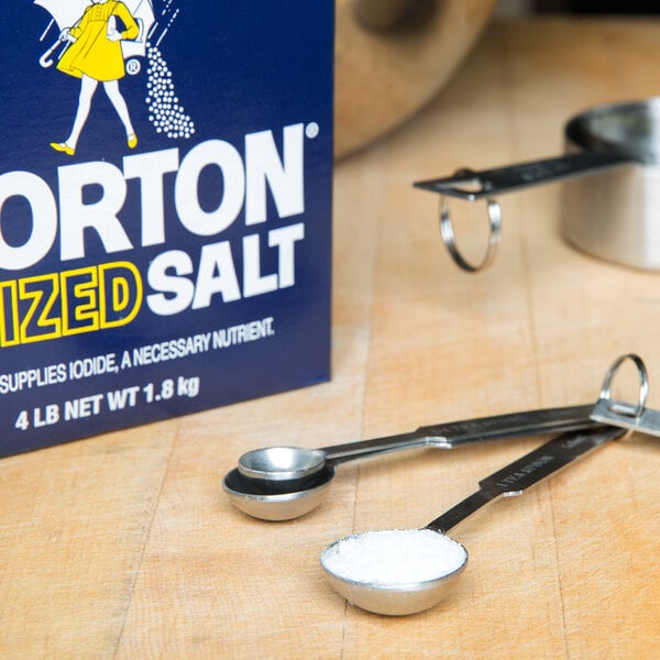 A box of Morton Iodized Table Salt sitting next to measuring spoons on a counter.