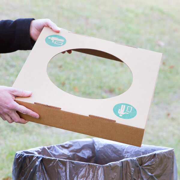 A person holding a Lavex cardboard container lid with a circle cut out in it.