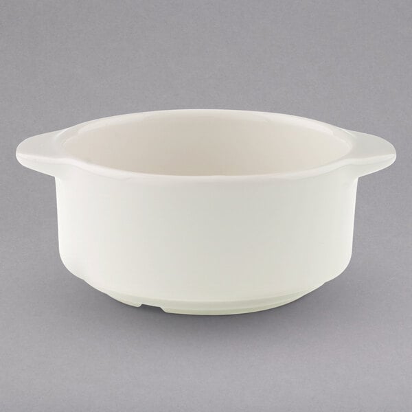 A white Villeroy & Boch porcelain soup bowl with a handle on a gray surface.