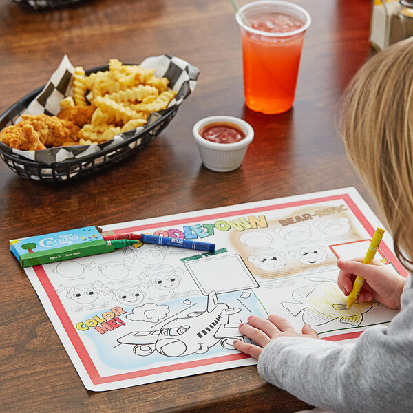 A child coloring a Hoffmaster Doodletown placemat on a table.