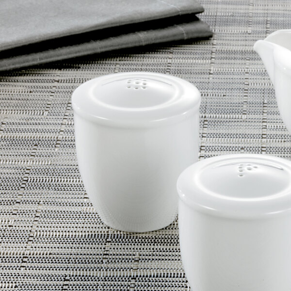 Two white Villeroy & Boch salt shakers on a table.