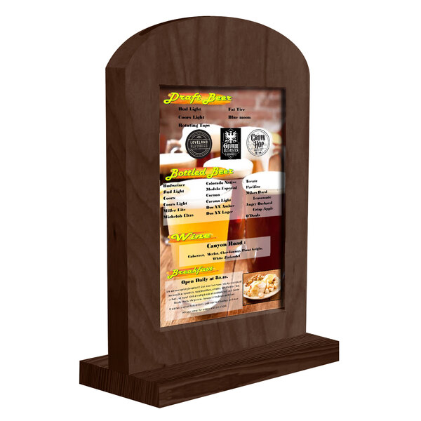 A Menu Solutions walnut wood arched table tent on a table with a menu inside.
