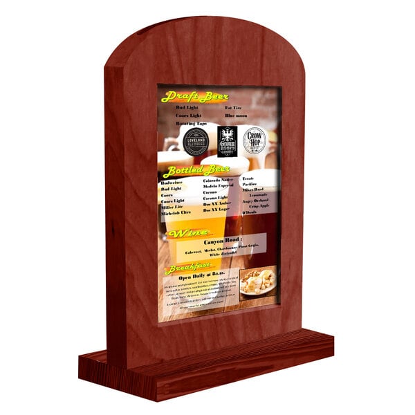 A Menu Solutions mahogany wood arched table tent with a menu in it.