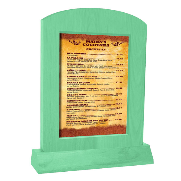 A Menu Solutions washed teal wood menu tent with an angled base on a table with a green surface.