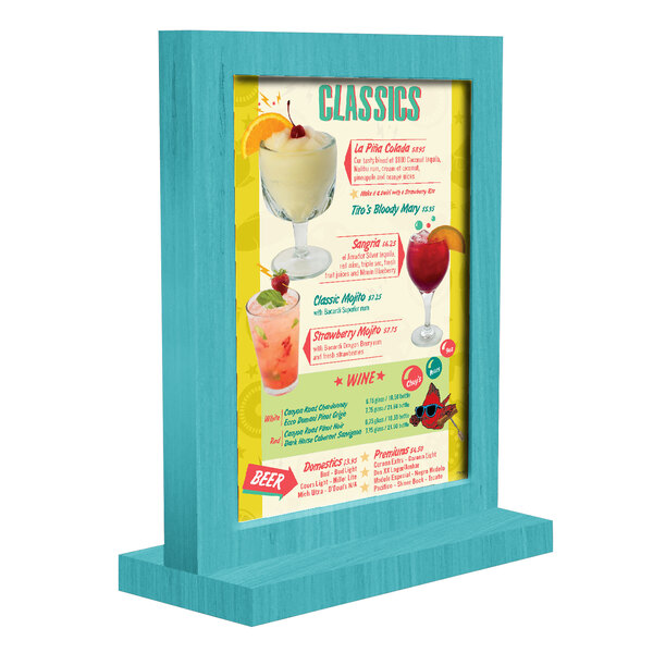 A sky blue wooden framed menu tent on a table in a cocktail bar.
