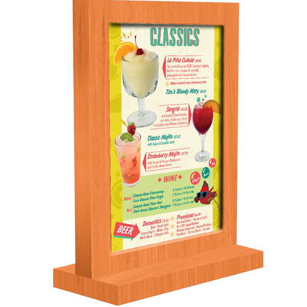 A Menu Solutions wooden menu tent with a mandarin wood frame on a table with drinks.