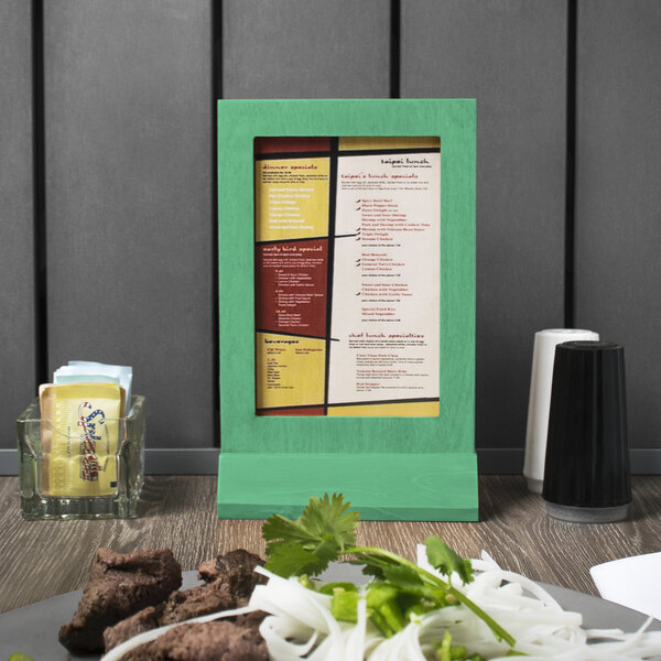 A Menu Solutions washed teal wood menu tent on a table.