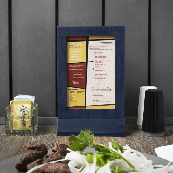 A Menu Solutions wood menu tent with a denim framed menu on a table.