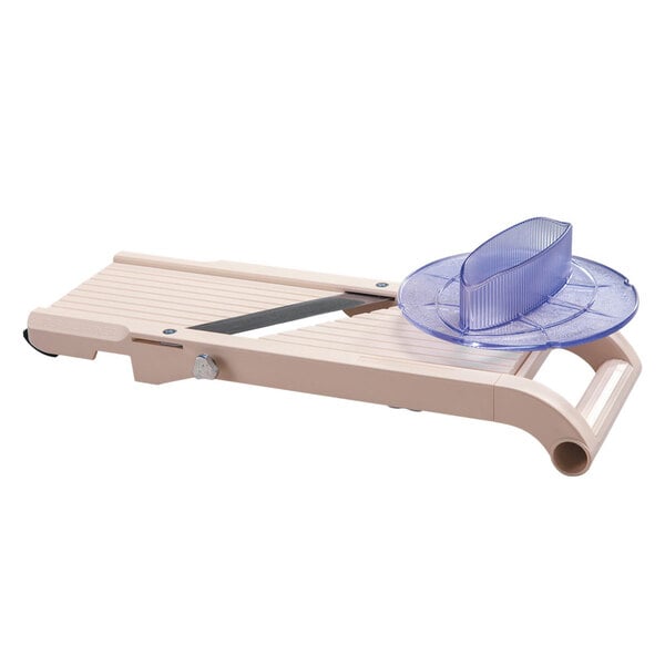 A Benriner Japanese plastic mandoline slicer on a table with a blue plastic plate.