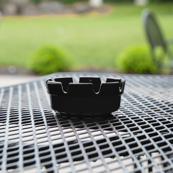 A black Choice plastic ashtray on a table.