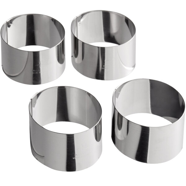 A pack of four silver stainless steel round ring molds with a hole in the center.