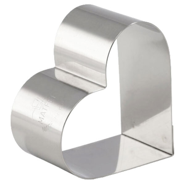 A close up of a stainless steel heart shaped ring mold.