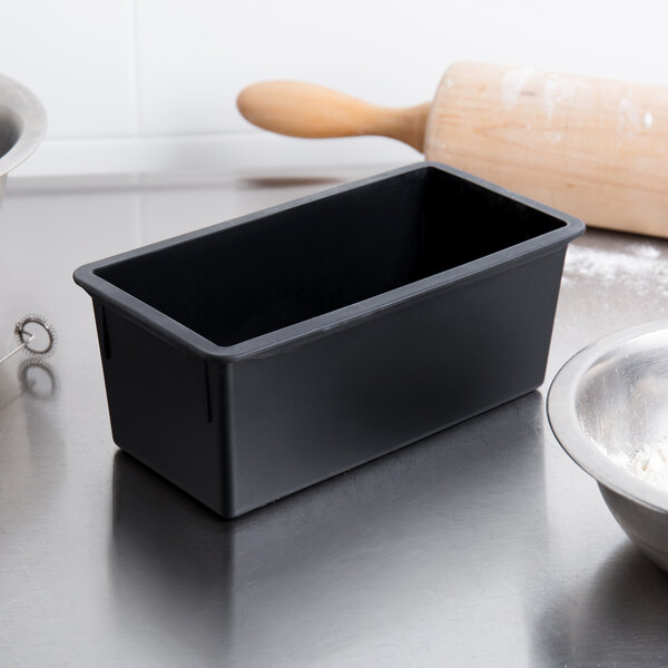 A black Matfer Bourgeat non-stick bread loaf pan on a kitchen counter next to a bowl.