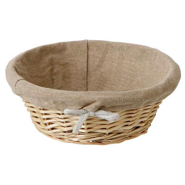 A Matfer Bourgeat round wicker bread basket with a linen lining and a bow on it.