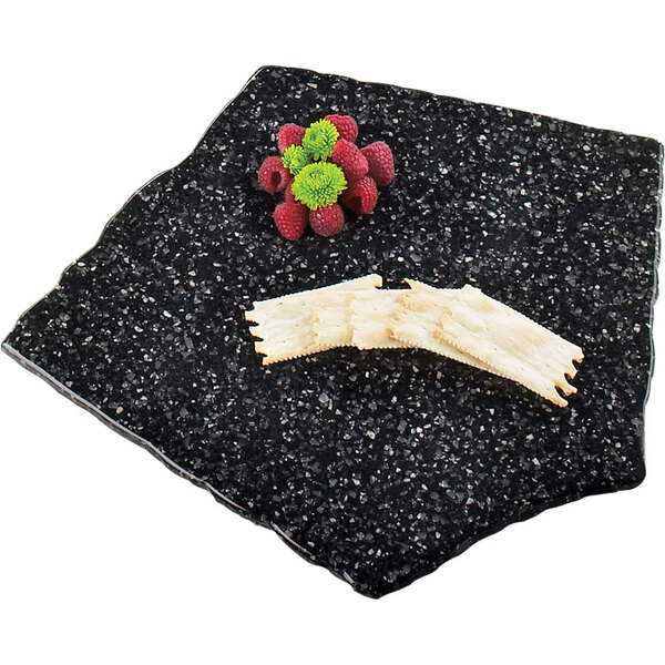 A black simulated stone tray with food and a knife on it.