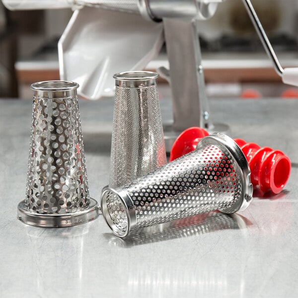 A stainless steel Weston strainer with a red handle, a metal cone with holes, and other metal accessories.