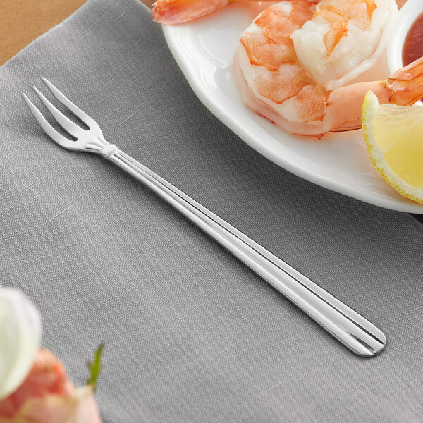 A plate of shrimp with a lemon and a fork.