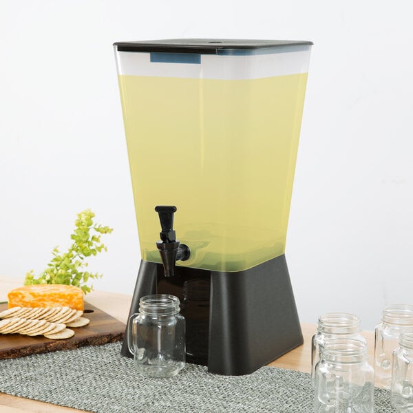 A black Choice beverage dispenser with yellow liquid on a table.