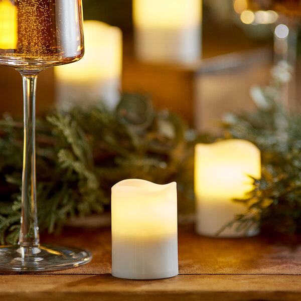 A glass of wine next to a Sterno warm white flameless votive candle.