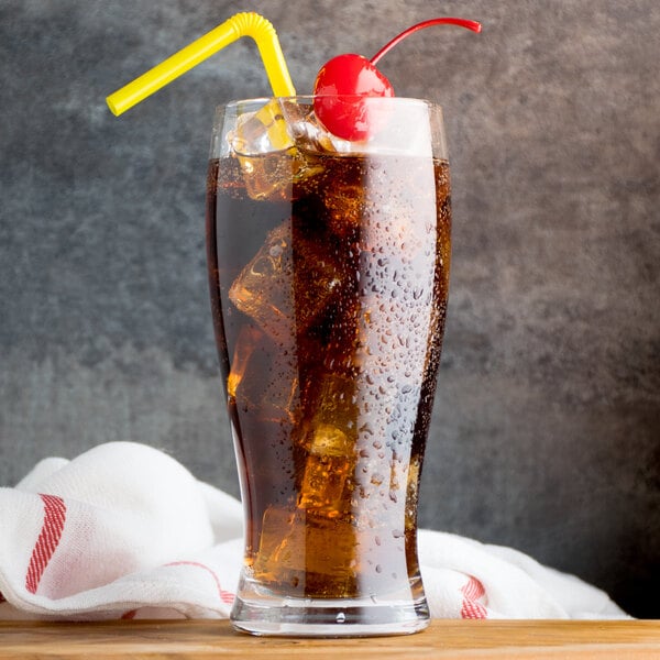 A glass of Narvon cherry cola with ice and a cherry.