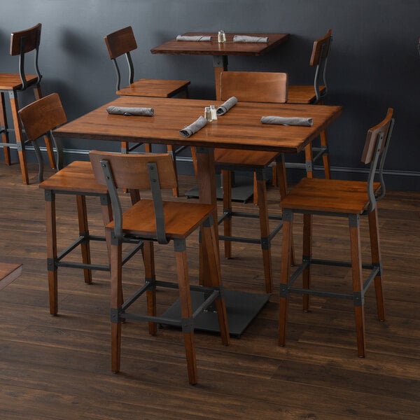 A Lancaster Table & Seating bar height table with chairs and napkins.