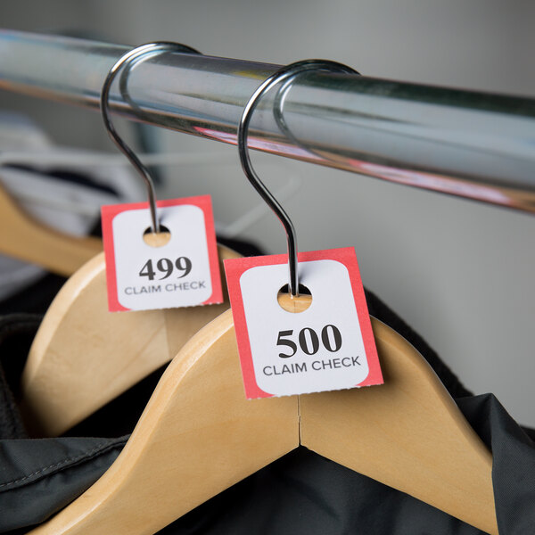 A metal rack with Choice Red paper coat check tickets on clips.