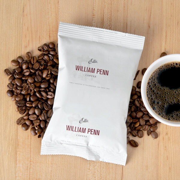 A William Penn regular coffee packet next to a cup of coffee.