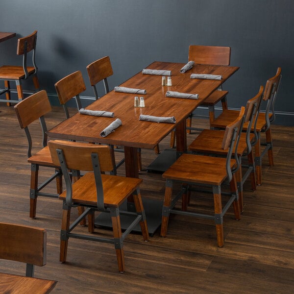 A Lancaster Table & Seating wooden table with wooden chairs.