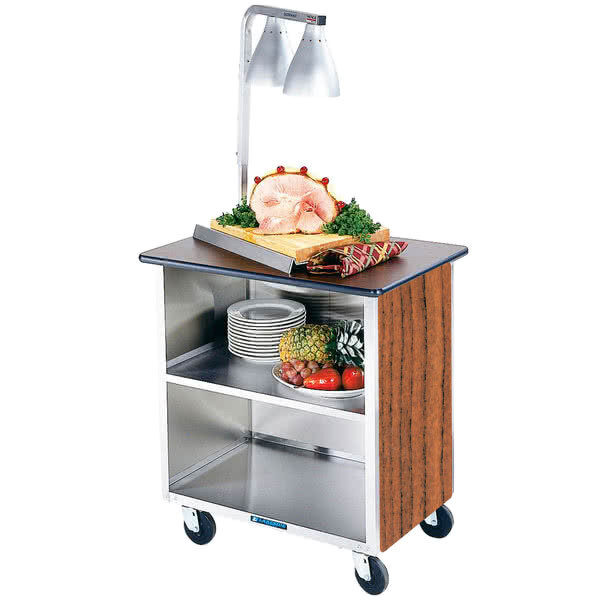 A Lakeside stainless steel utility cart with food on top and plates on the shelves.