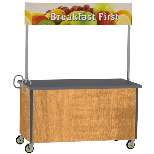 A Lakeside stainless steel vending cart with a light maple laminate finish and a sign that says "Breakfast First" with a close up of fruit.