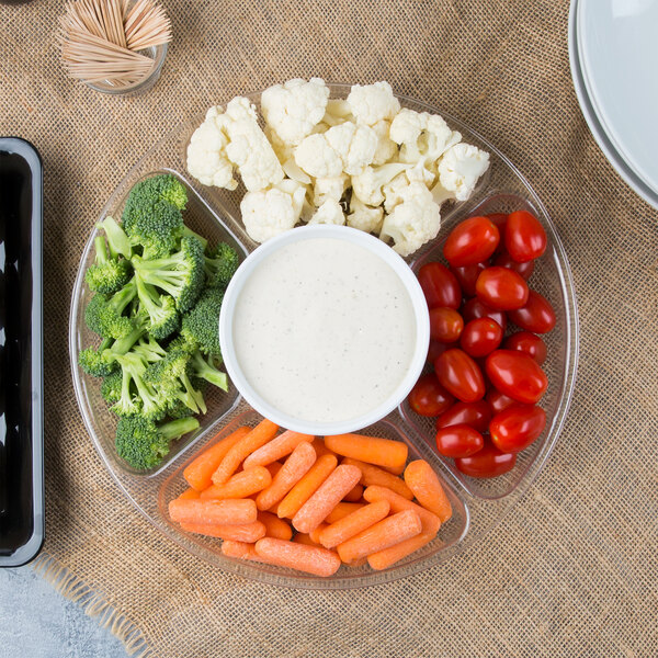A Fineline clear plastic 5-compartment tray with baby carrots, broccoli, and dip on a counter.