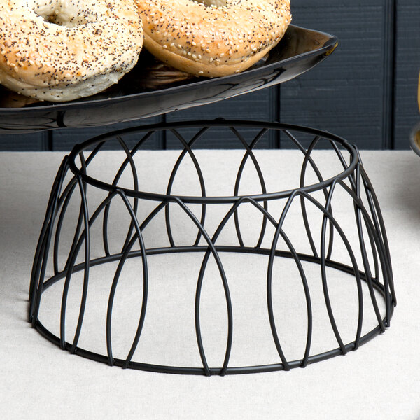A tray of bagels on a black patterned metal display stand.