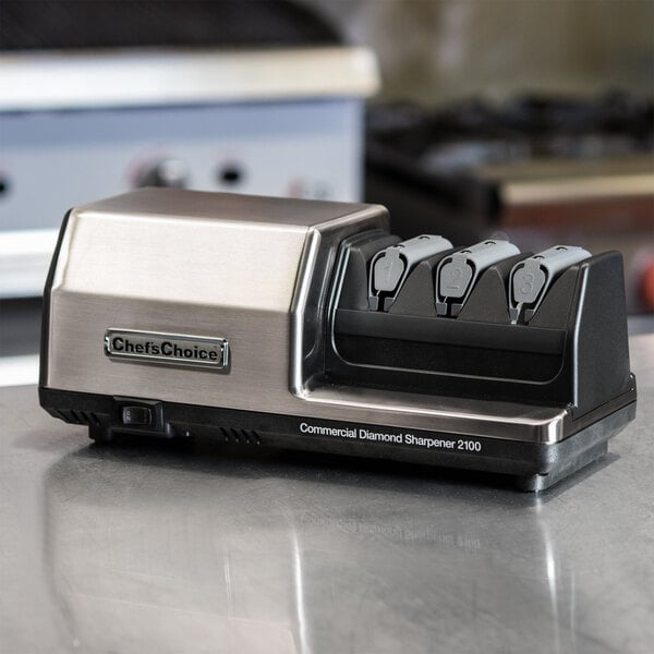A silver Edgecraft Chef's Choice 3 stage knife sharpener on a counter.