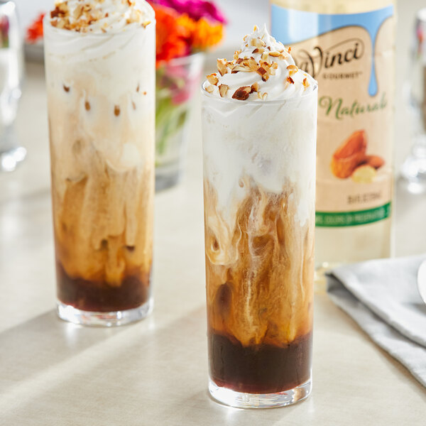 A close-up of two glasses of DaVinci Gourmet almond flavored drinks with whipped cream.