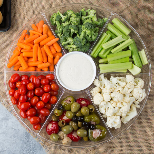 A Fineline clear plastic tray with 7 compartments holding baby carrots, broccoli, and dip.