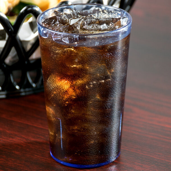 A Cambro slate blue plastic tumbler filled with ice and brown liquid on a table.
