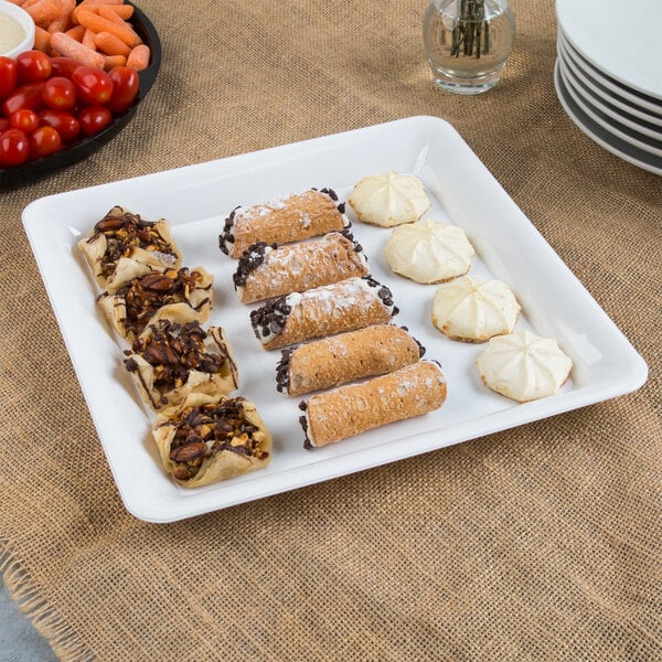 A Fineline white plastic square catering tray with pastries and desserts on it.
