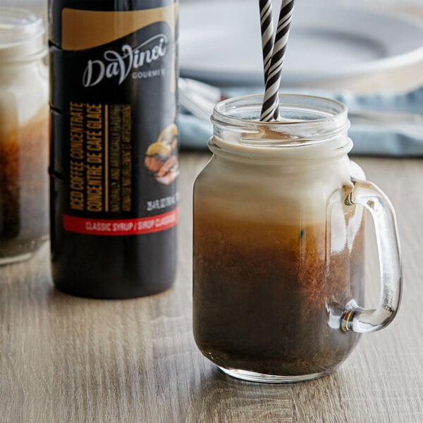 A DaVinci Gourmet jar filled with brown liquid with a straw in it.