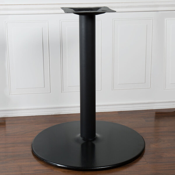 A BFM Seating sand black stamped steel round table base for a restaurant table.