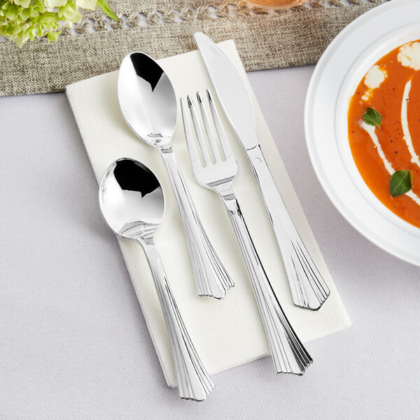 A Visions silver plastic cutlery set on a napkin with a fork and spoon.