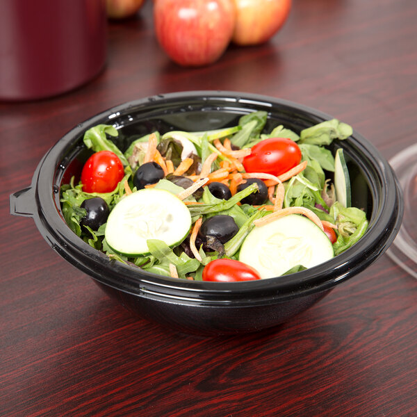 A bowl of salad with vegetables in a black bowl.