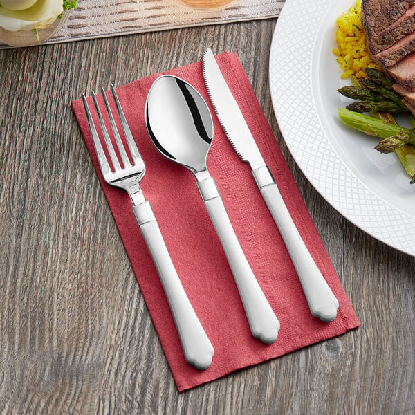 A Visions white plastic fork, spoon, and knife on a red napkin.