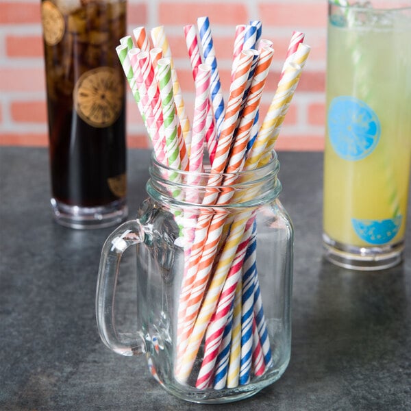 A glass jar filled with Creative Converting striped paper straws.