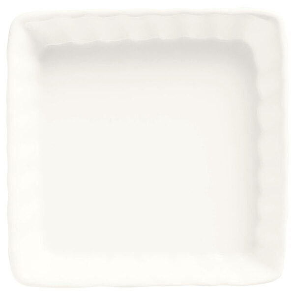 A white square Libbey Bedrock creme brulee dish with wavy edges.