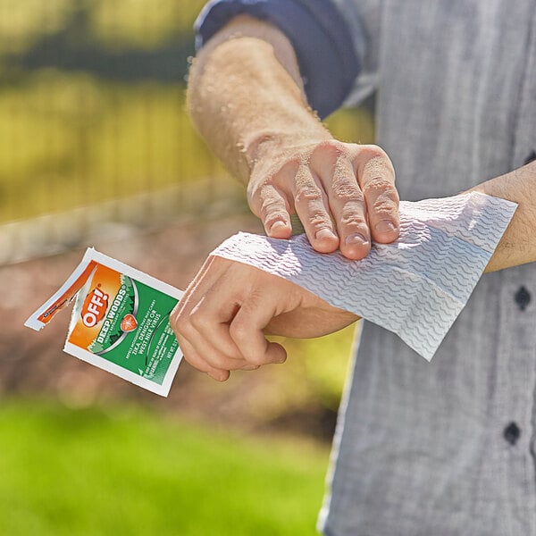 A person using an OFF! Deep Woods insect repellent towelette to wipe their wrist.
