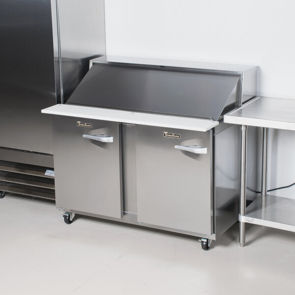 A Traulsen stainless steel refrigerated sandwich prep table with left hinged doors.