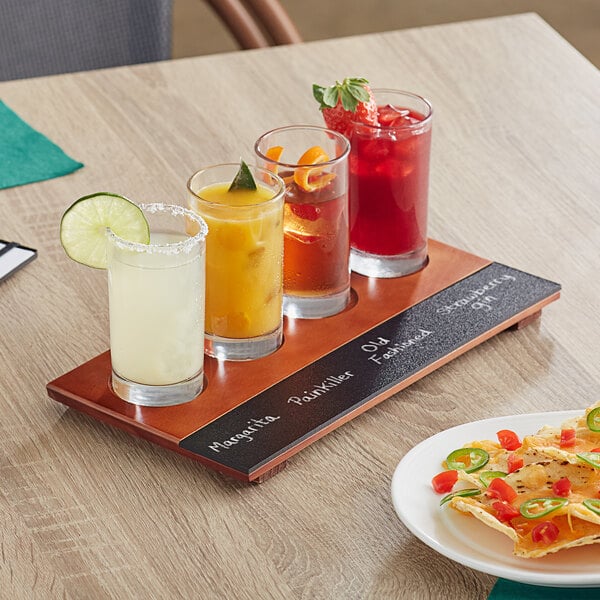 An Acopa flight tray with Straight Up Tasting Glasses filled with three different drinks on a table.