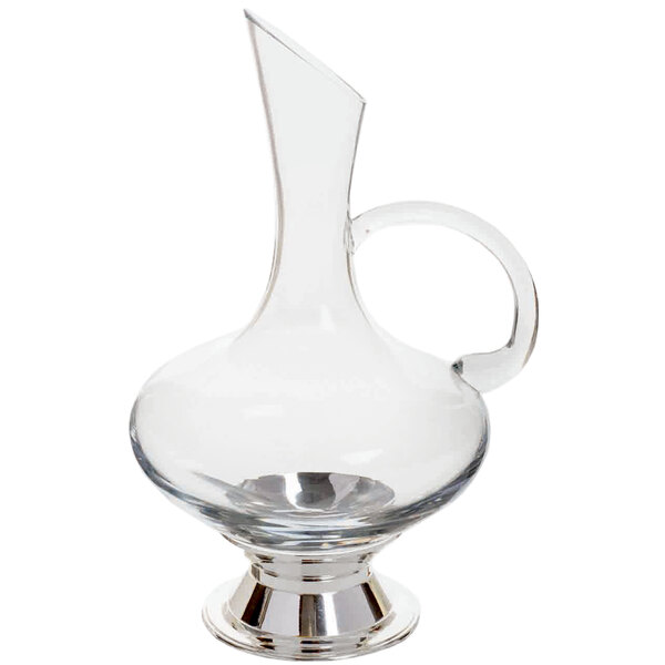 A clear glass pitcher with a handle and silver plated base.