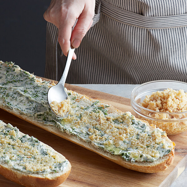Minced garlic spread on a long loaf of bread.