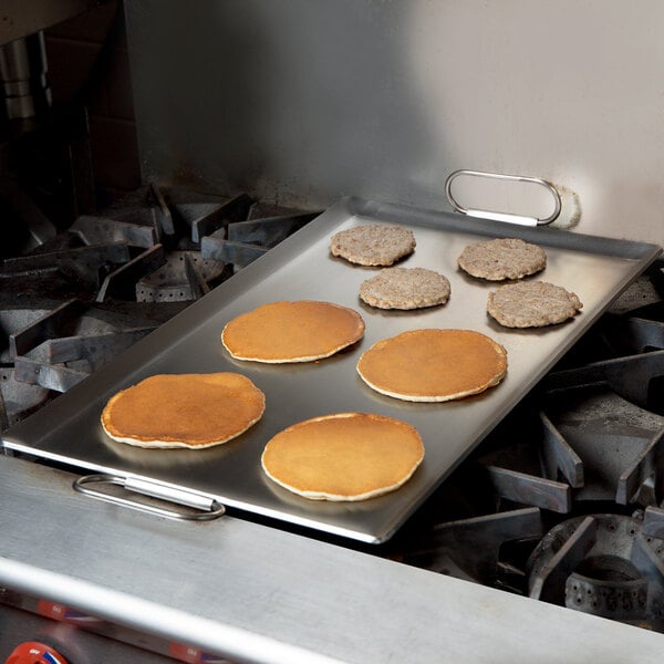 A pancake cooking on a Vigor steel griddle on a stove.